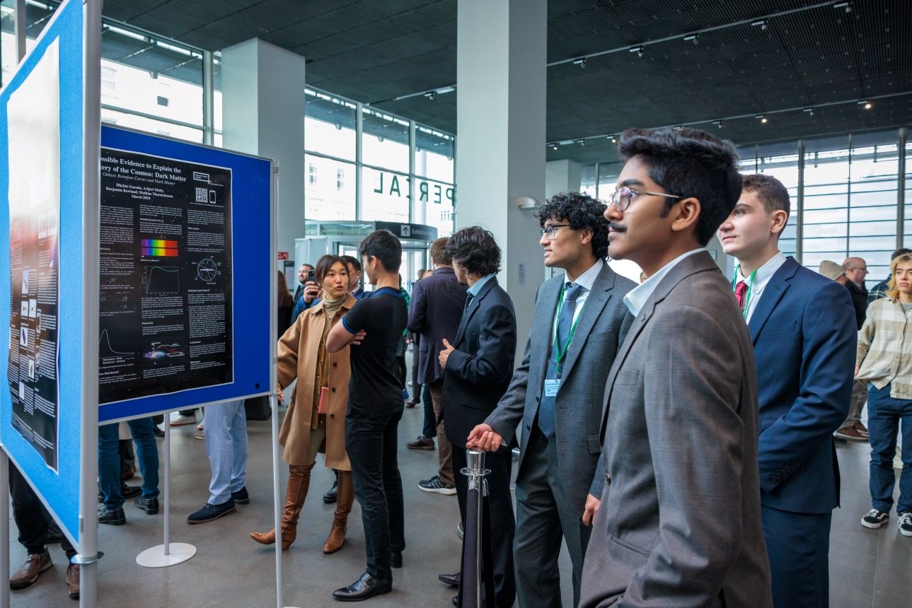 Students look at each other's posters during a break between presentations